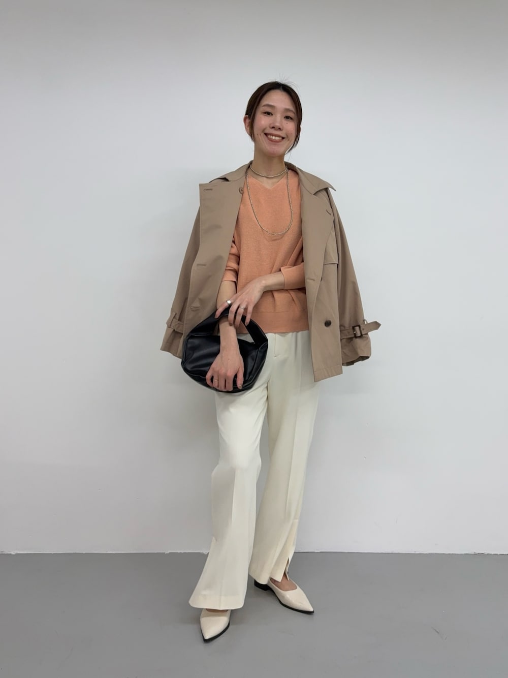 ピンク系のニット/セーター、ブラック系のハンドバッグ、ホワイト系のその他シューズを着用したレディースの冬コーディネートの1枚目の写真