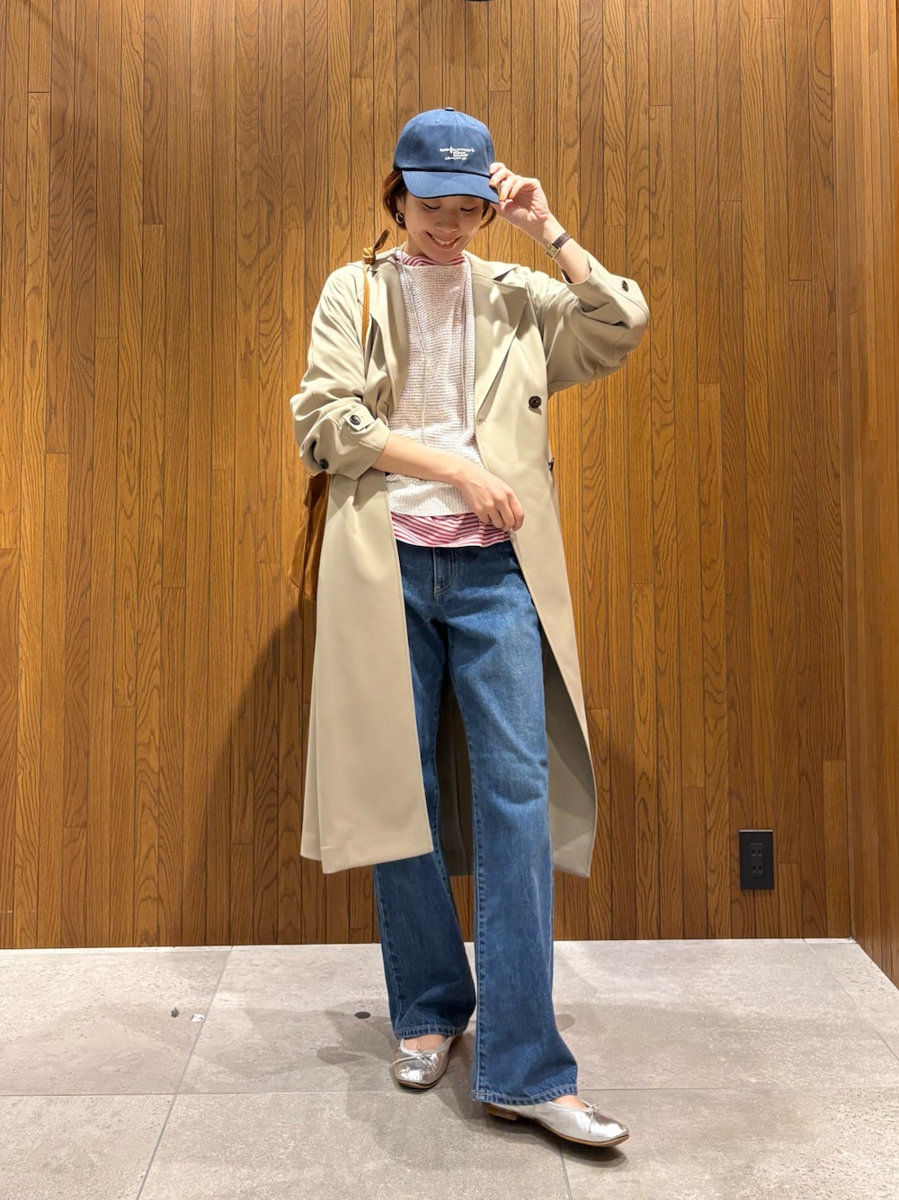 ベージュ系のトレンチコート、レッド系のTシャツ/カットソー、ホワイト系のニット/セーターを着用したレディースの春コーディネートの1枚目の写真