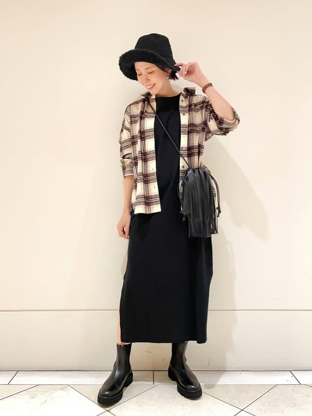 ベージュ系のシャツ/ブラウス、ブラック系のワンピース、ブラック系のブーツを着用したレディースの秋コーディネートの1枚目の写真