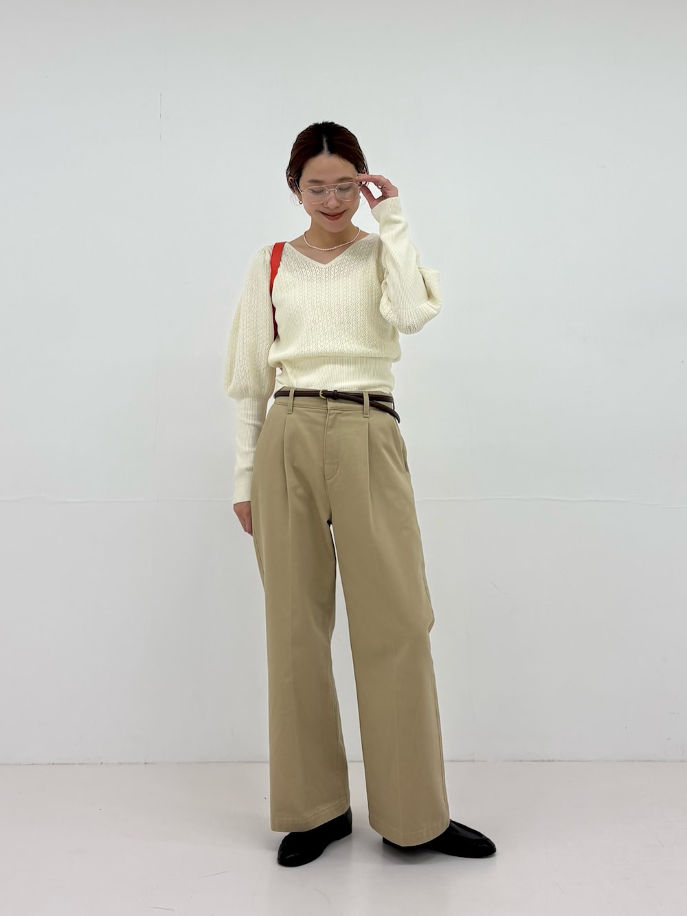 ホワイト系のニット/セーター、ベージュ系のその他パンツ、ブラック系のローファーを着用したレディースの夏コーディネートの1枚目の写真