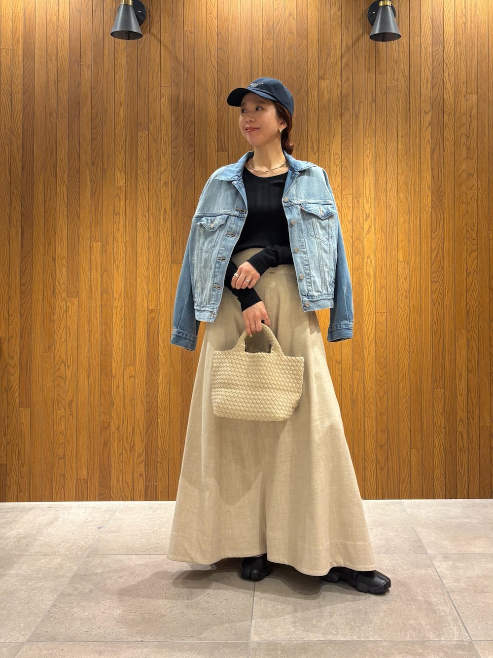 ホワイト系のトートバッグ、ブラック系のTシャツ/カットソー、ブルー系のデニムジャケットを着用したレディースの春コーディネートの1枚目の写真