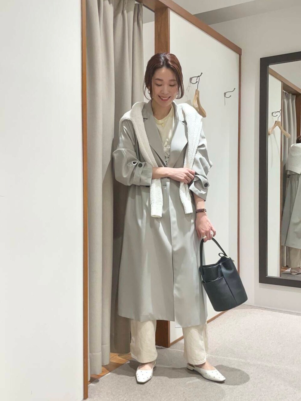 イエロー系のTシャツ/カットソー、グリーン系のトレンチコート、ホワイト系のニット/セーターを着用したレディースの春コーディネートの1枚目の写真