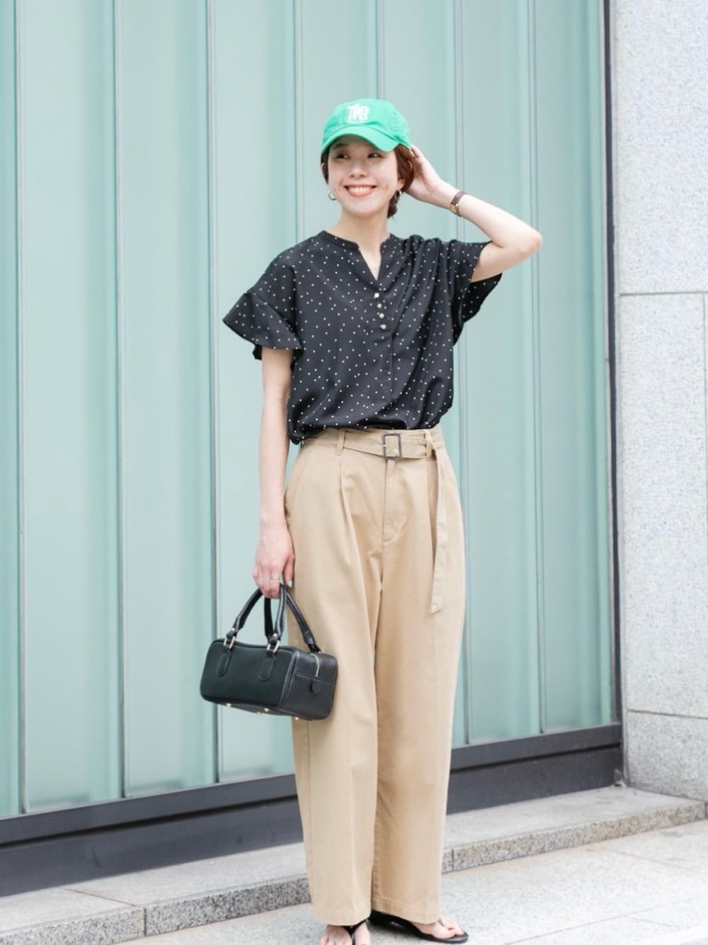 ベージュ系のその他パンツ、ブラック系のハンドバッグ、ブラック系のサンダルを着用したレディースの春コーディネートの1枚目の写真