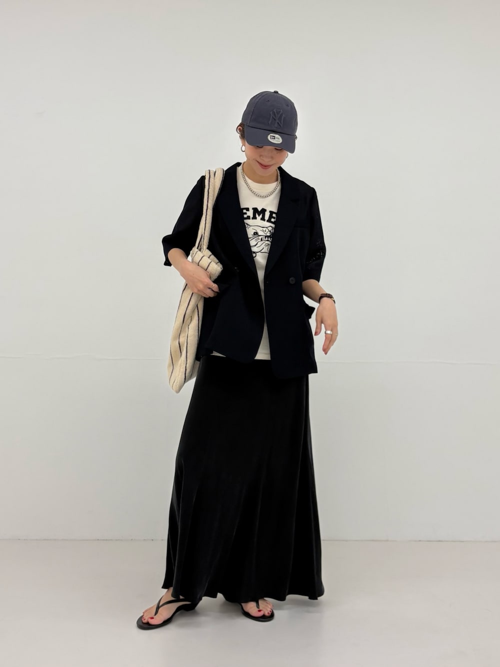 ブルー系のその他アウター、ブラック系のスカート、ベージュ系のTシャツ/カットソーを着用したレディースの春コーディネートの1枚目の写真