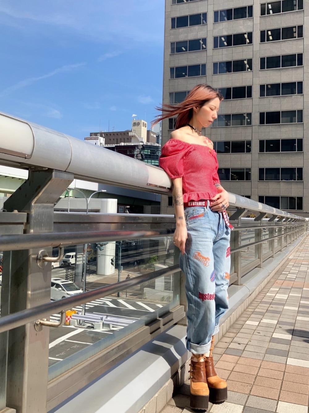 レッド系のTシャツ/カットソー、ブルー系のデニムパンツ、ブラック系のチョーカーを着用したレディースの春コーディネートの1枚目の写真