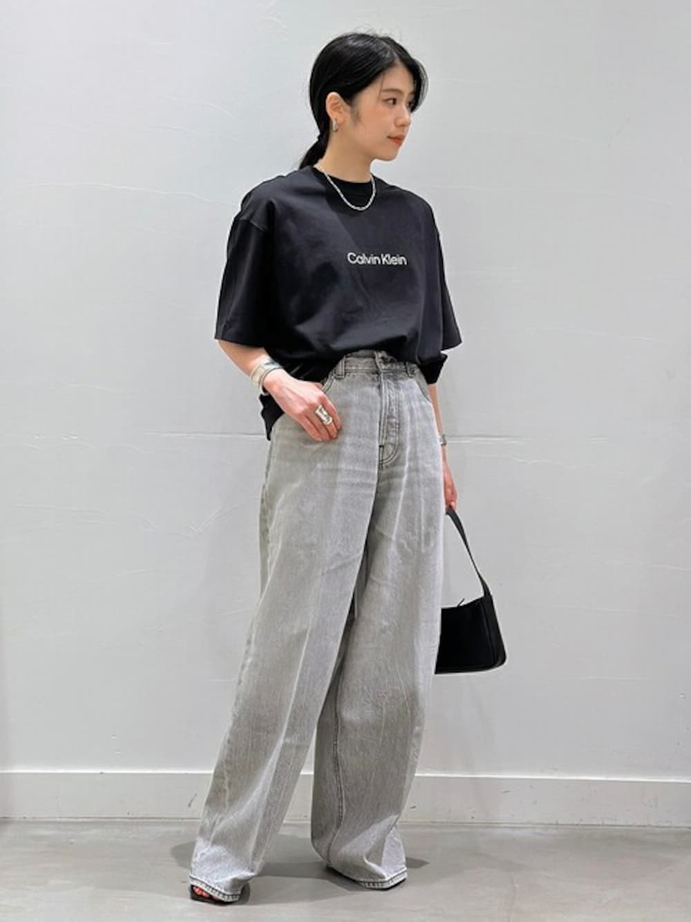 ブラック系のTシャツ/カットソー、グレー系のデニムパンツ、ブラック系のハンドバッグを着用したレディースの夏コーディネートの1枚目の写真