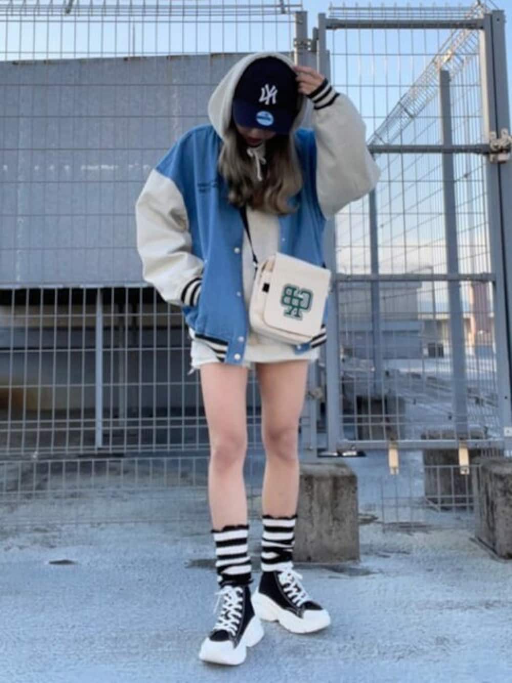 その他のショルダーバッグ、ブルー系のスタジャン、ブラック系のスニーカーを着用したレディースの冬コーディネートの1枚目の写真