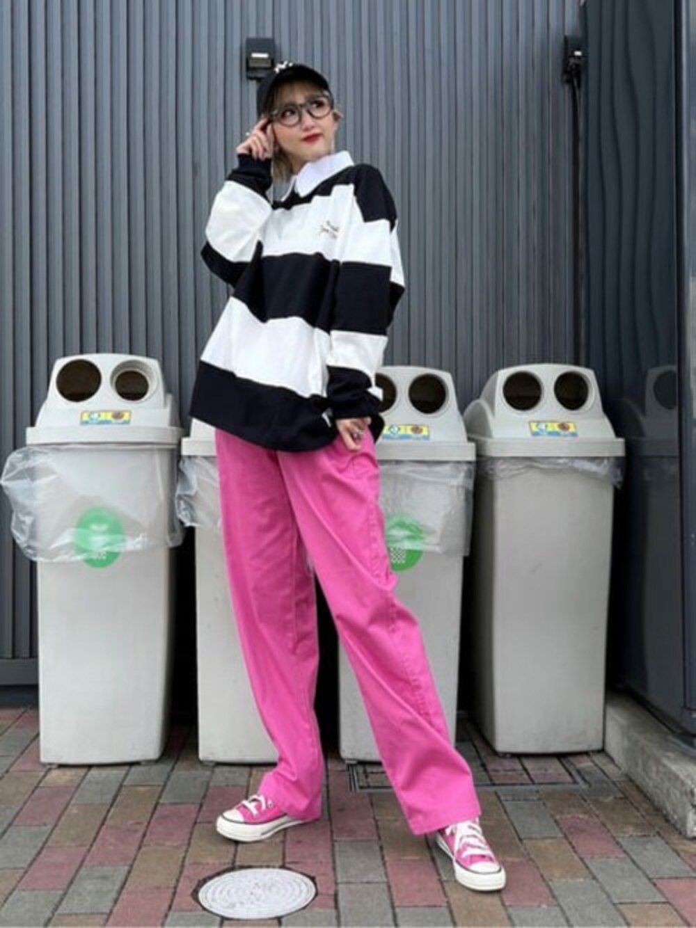 その他のポロシャツ、ピンク系のチノパンツ、ブラック系のキャップを着用したレディースの冬コーディネートの1枚目の写真