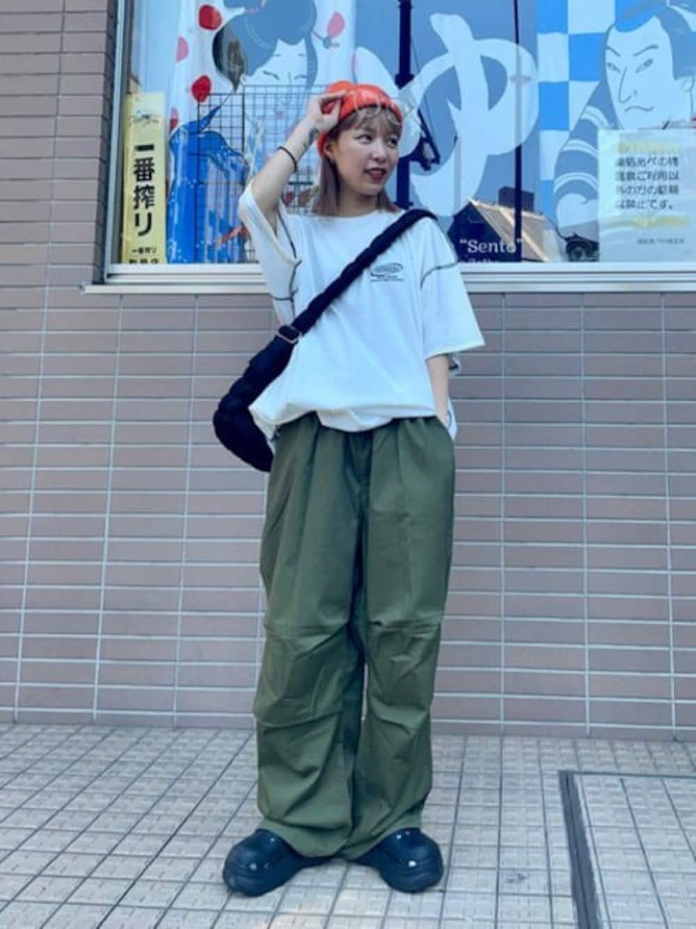 ホワイト系のTシャツ/カットソー、グリーン系のカーゴパンツ、ブラック系のショルダーバッグを着用したレディースの夏コーディネートの1枚目の写真