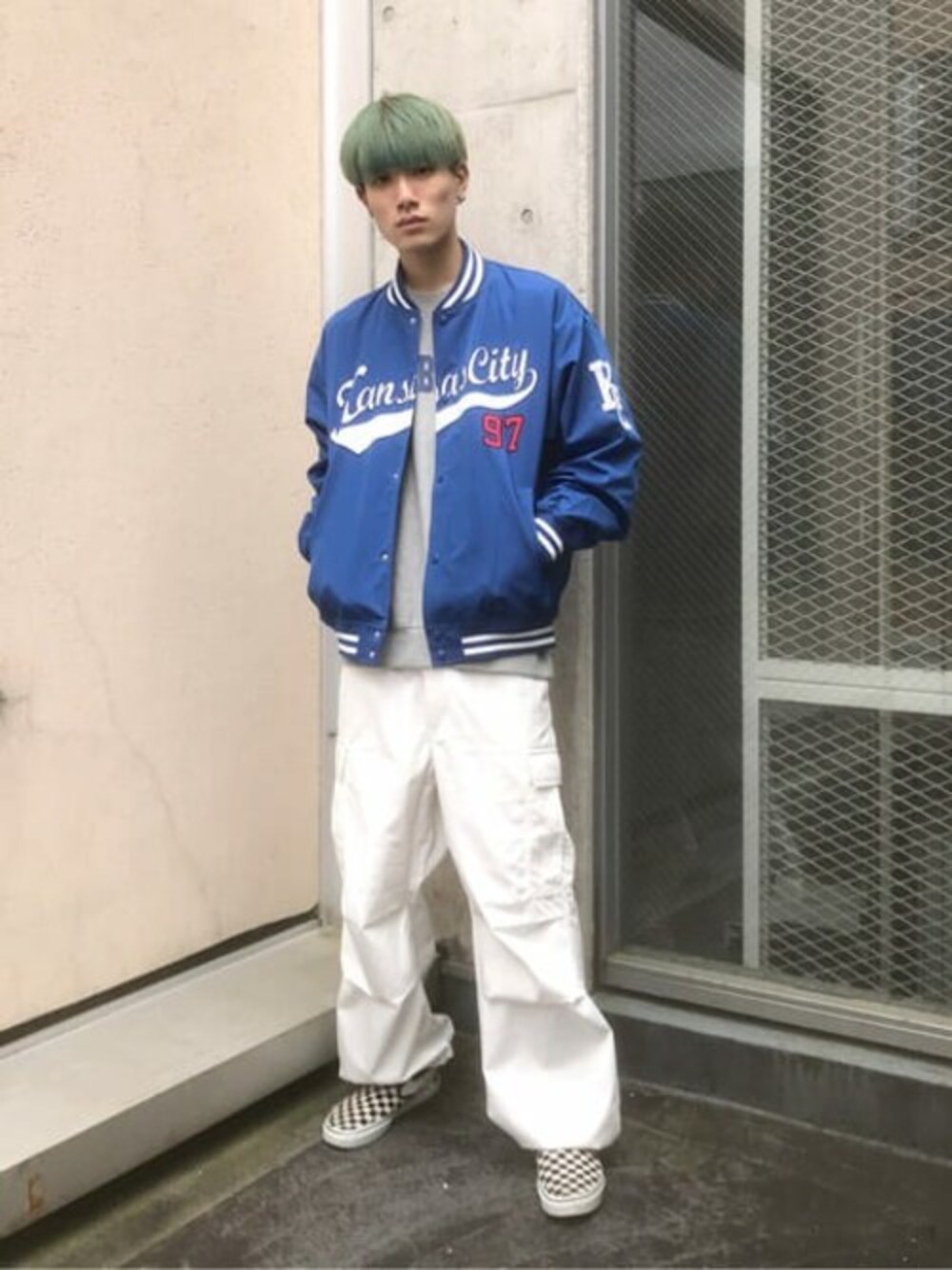 グレー系のスウェット、ブルー系のスタジャン、ホワイト系のカーゴパンツを着用したメンズの秋コーディネートの1枚目の写真