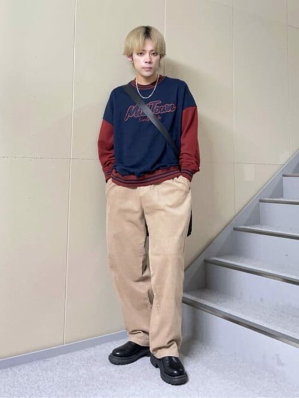 ブルー系のスウェット、ベージュ系のチノパンツ、その他のショルダーバッグを着用したメンズの冬コーディネートの1枚目の写真