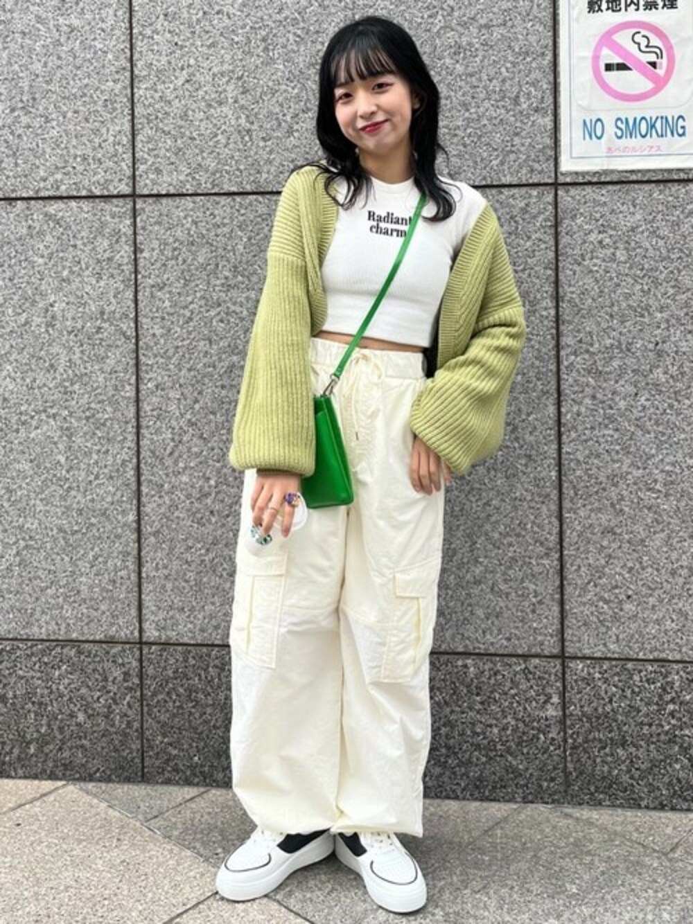 グリーン系のカーディガン/ボレロ、ホワイト系のTシャツ/カットソー、グリーン系のショルダーバッグを着用したレディースの冬コーディネートの1枚目の写真