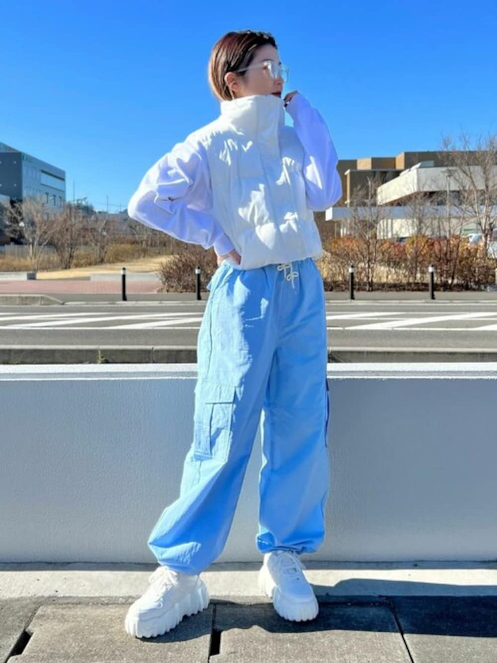 ホワイト系のダウンベスト、ホワイト系のTシャツ/カットソー、ブルー系のカーゴパンツを着用したレディースの冬コーディネートの1枚目の写真