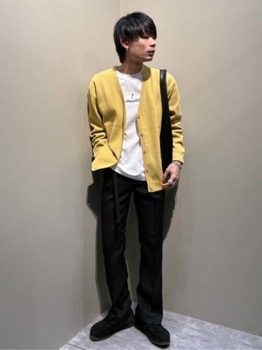 イエロー系のカーディガン/ボレロ、ホワイト系のTシャツ/カットソー、ブラック系のスラックスを着用したメンズの春コーディネートの1枚目の写真