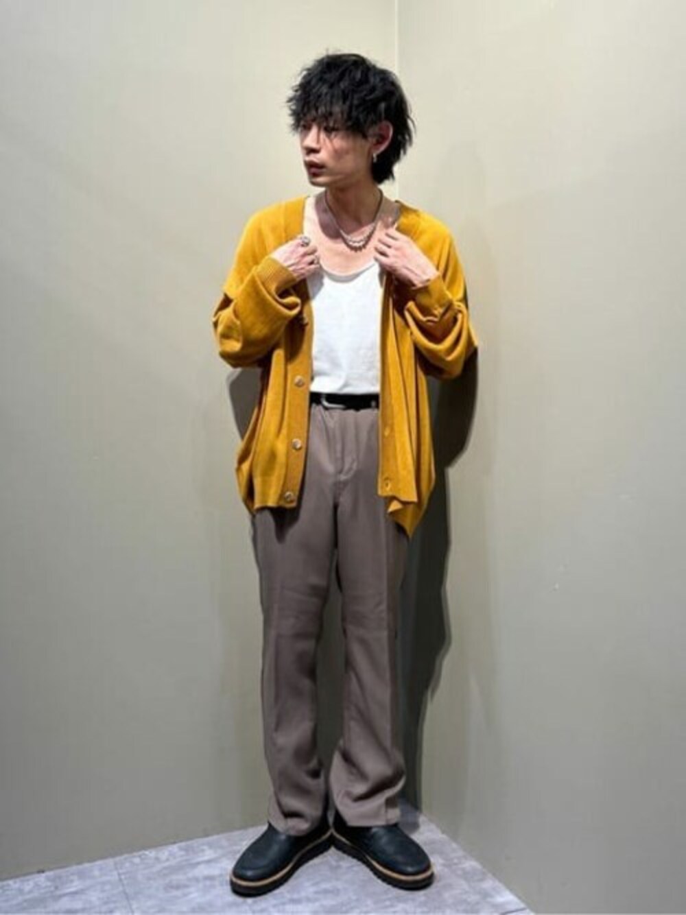 イエロー系のカーディガン/ボレロ、ホワイト系のタンクトップ、ブラウン系のスラックスを着用したメンズの春コーディネートの1枚目の写真