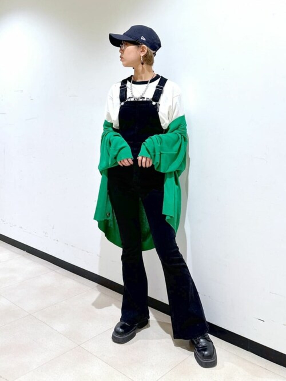 グリーン系のカーディガン/ボレロ、ブラック系のサロペット/オーバーオール、ホワイト系のTシャツ/カットソーを着用したレディースの春コーディネートの1枚目の写真