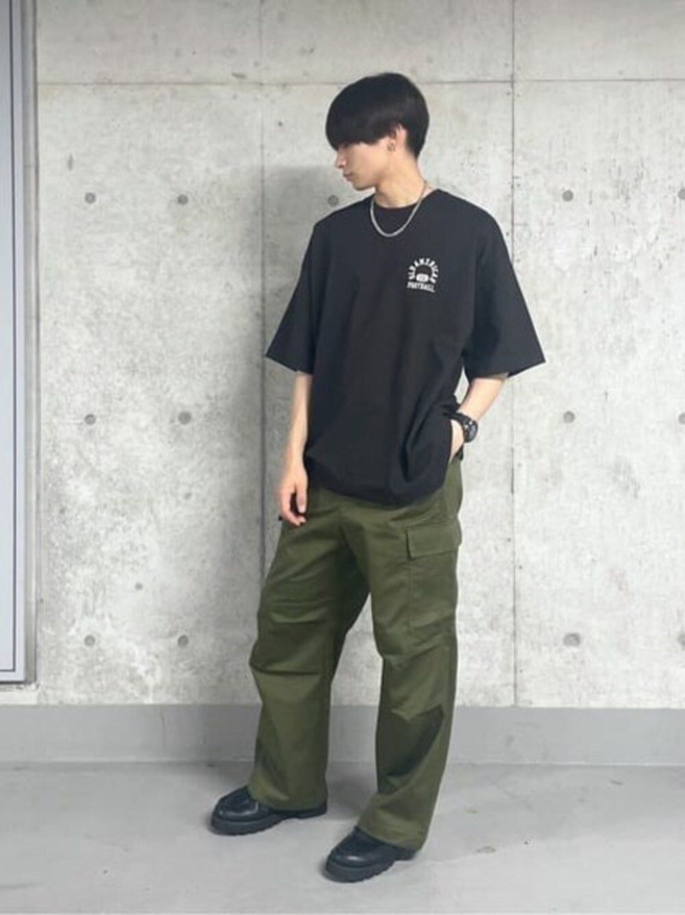 ブラック系のTシャツ/カットソー、グリーン系のカーゴパンツを着用したメンズの夏コーディネートの1枚目の写真