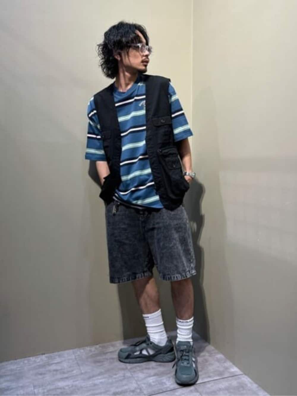 ブラック系のベスト、ブルー系のTシャツ/カットソー、ブラック系のデニムパンツを着用したメンズの夏コーディネートの1枚目の写真