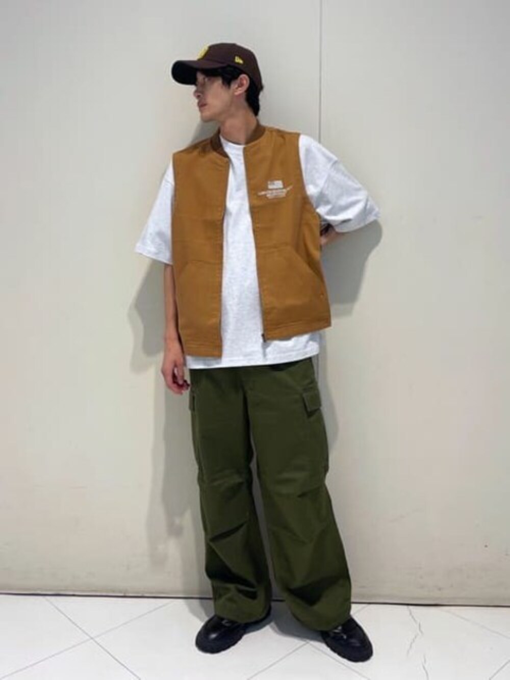 ブラウン系のベスト、グレー系のTシャツ/カットソー、グリーン系のカーゴパンツを着用したメンズの夏コーディネートの1枚目の写真