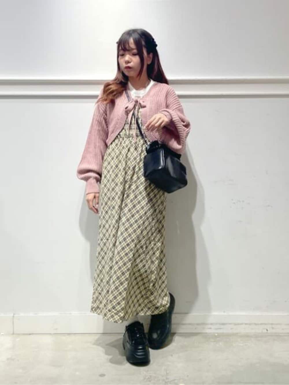 ピンク系のカーディガン/ボレロ、ベージュ系のワンピース、ブラック系のスニーカーを着用したレディースの夏コーディネートの1枚目の写真