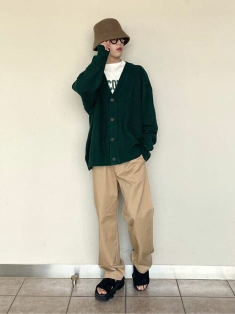 グリーン系のカーディガン/ボレロ、その他のTシャツ/カットソー、ベージュ系のチノパンツを着用したメンズの秋コーディネートの1枚目の写真