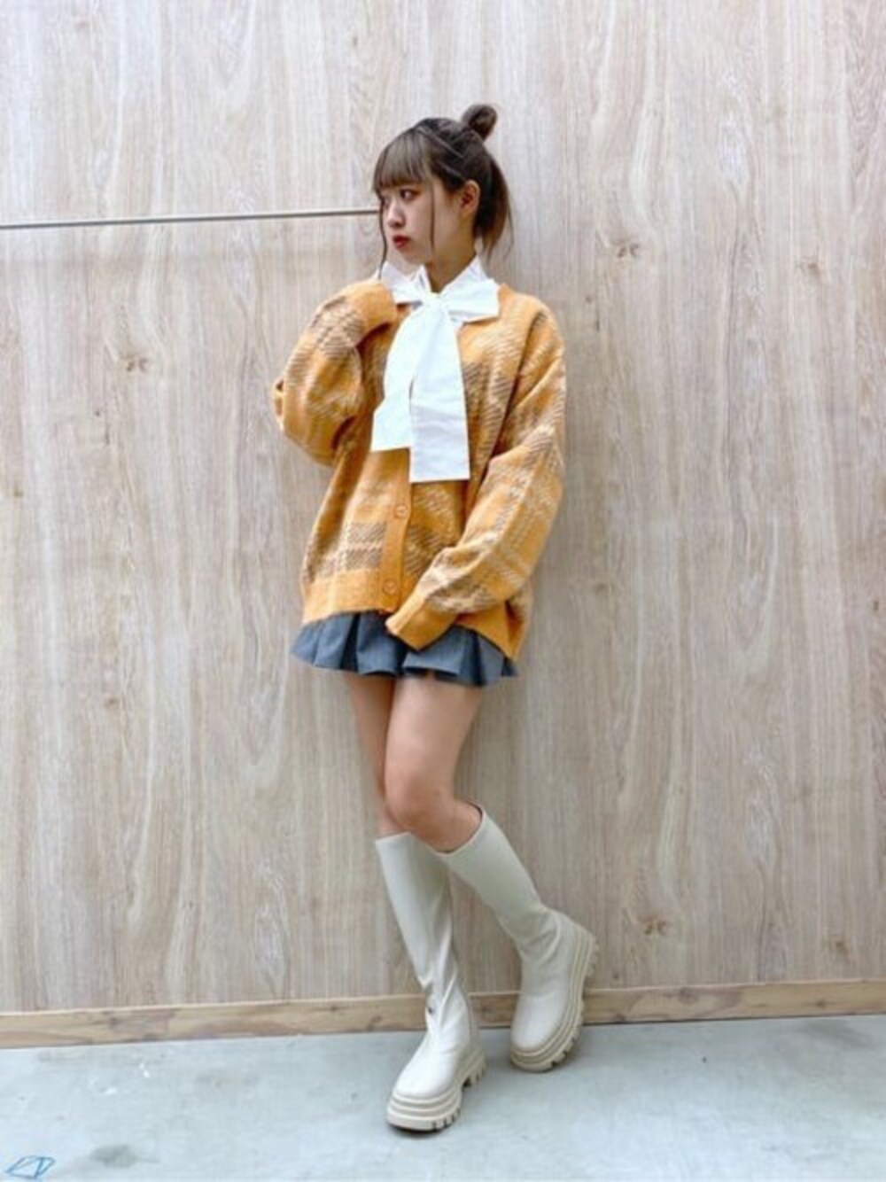 オレンジ系のカーディガン/ボレロ、ホワイト系のシャツ/ブラウス、グレー系のスカートを着用したレディースの冬コーディネートの1枚目の写真