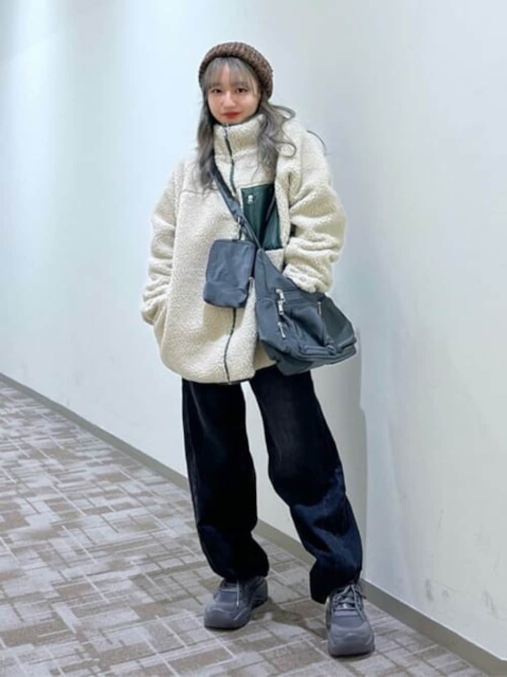 ベージュ系のブルゾン、ブラック系のデニムパンツ、グレー系のショルダーバッグを着用したレディースの冬コーディネートの1枚目の写真