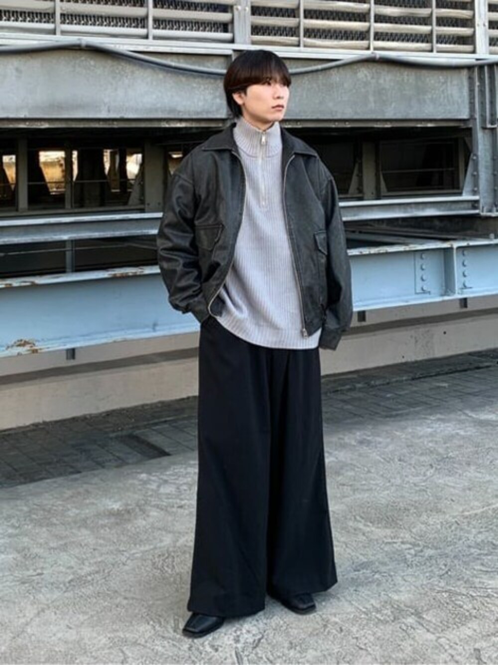 グレー系のニット/セーター、ブラック系のスラックスを着用したメンズの冬コーディネートの1枚目の写真