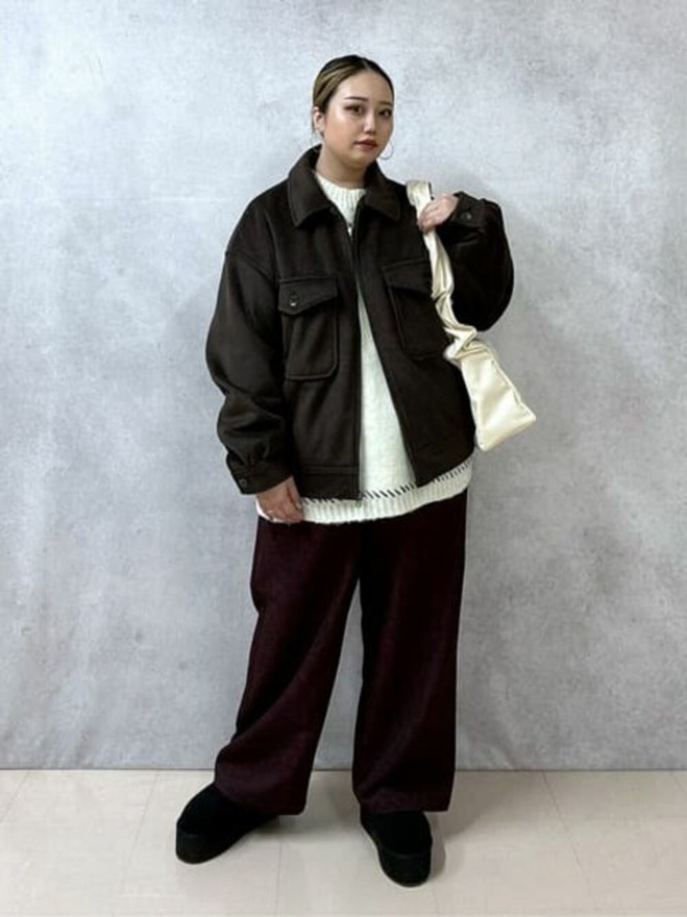 ホワイト系のニット/セーター、その他のスラックス、ブラウン系のブルゾンを着用したレディースの冬コーディネートの1枚目の写真