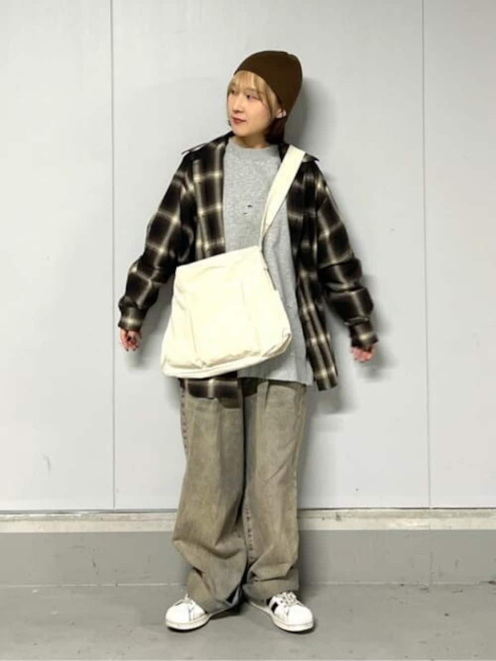 ブラウン系のシャツ/ブラウス、レッド系のデニムパンツ、ベージュ系のショルダーバッグを着用したレディースの冬コーディネートの1枚目の写真