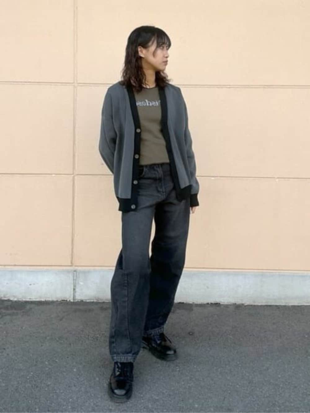 グリーン系のTシャツ/カットソー、ブラック系のカーディガン/ボレロ、ブラック系のデニムパンツを着用したレディースの冬コーディネートの1枚目の写真