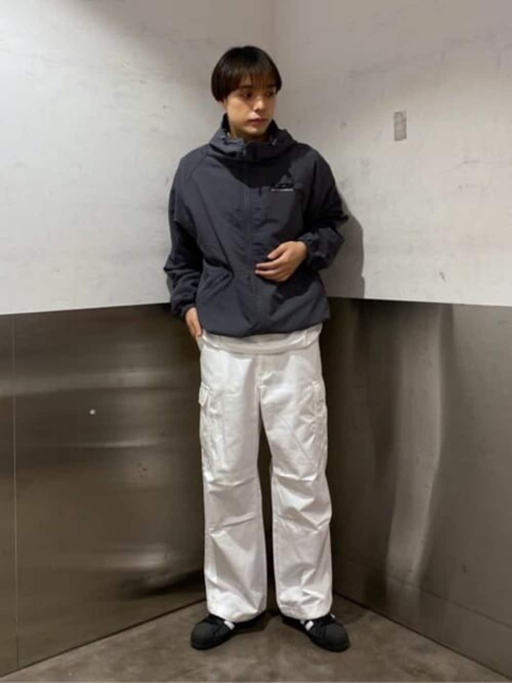 グレー系のブルゾン、ホワイト系のカーゴパンツを着用したメンズの春コーディネートの1枚目の写真