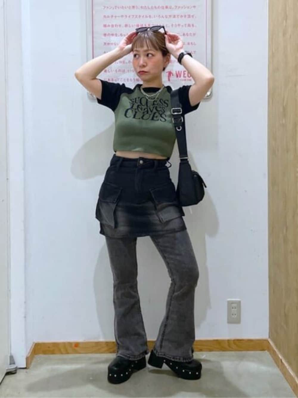 グリーン系のTシャツ/カットソー、ブラック系のデニムパンツ、ブラック系のデニムスカートを着用したレディースの春コーディネートの1枚目の写真