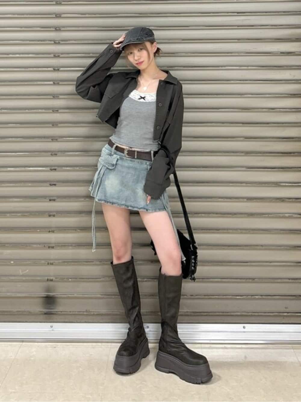 ブルー系のデニムスカート、ブラウン系のブーツ、ブラック系のキャミソールを着用したレディースの秋コーディネートの1枚目の写真