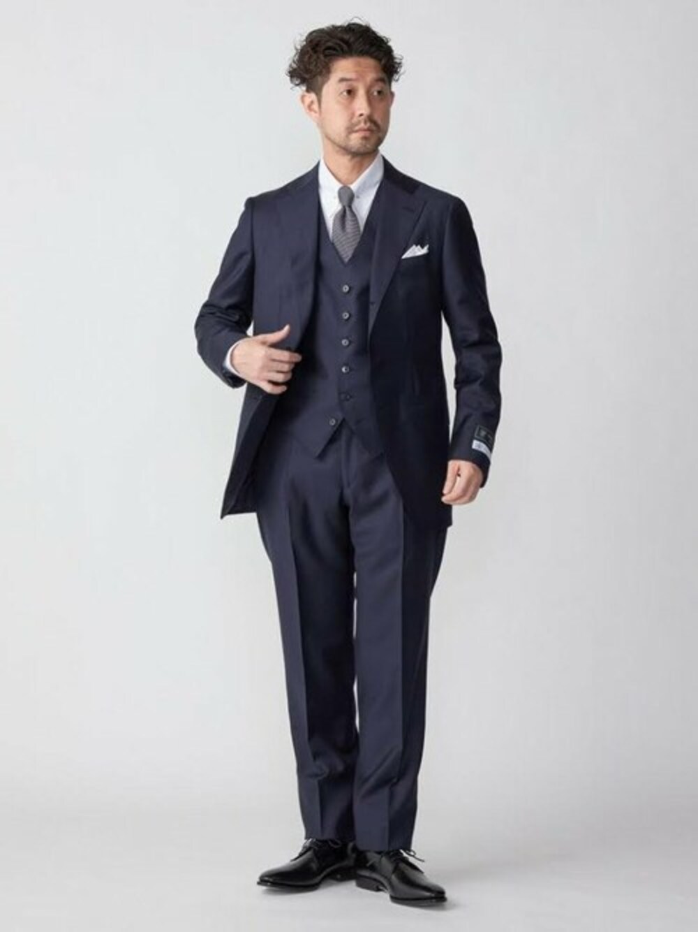 ブラック系のドレスシューズ、ホワイト系のポケットチーフを着用したメンズの冬コーディネートの1枚目の写真