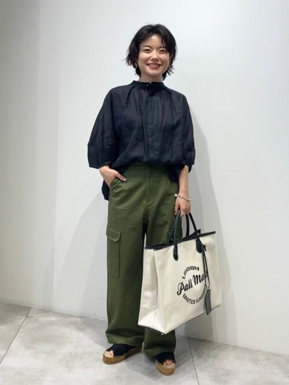 ブラック系のシャツ/ブラウス、グリーン系のその他パンツ、ブラック系のトートバッグを着用したレディースの夏コーディネートの1枚目の写真