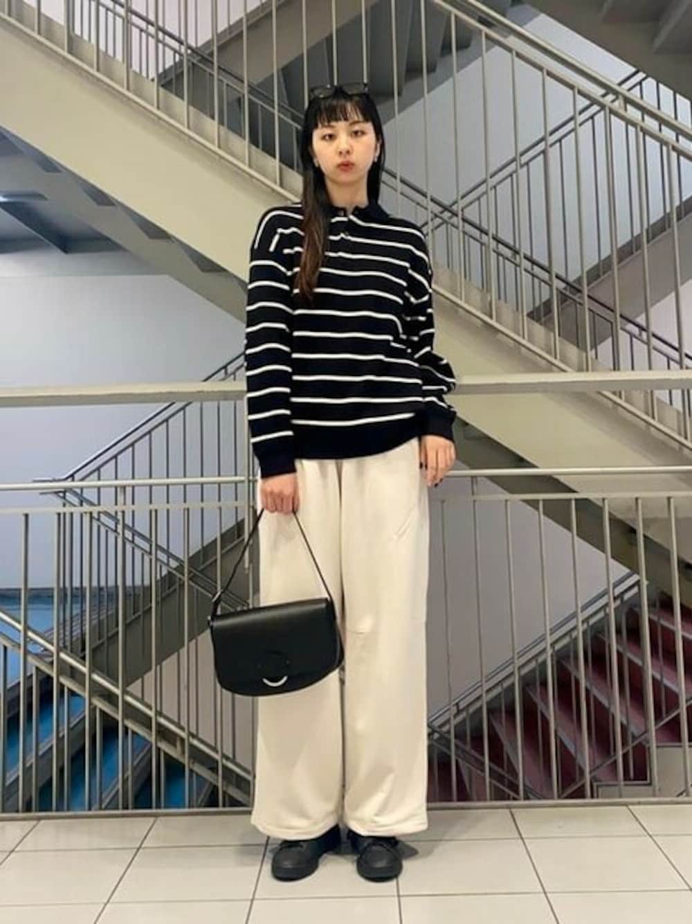 ブラック系のポロシャツ、グレー系のカーゴパンツを着用したレディースの冬コーディネートの1枚目の写真