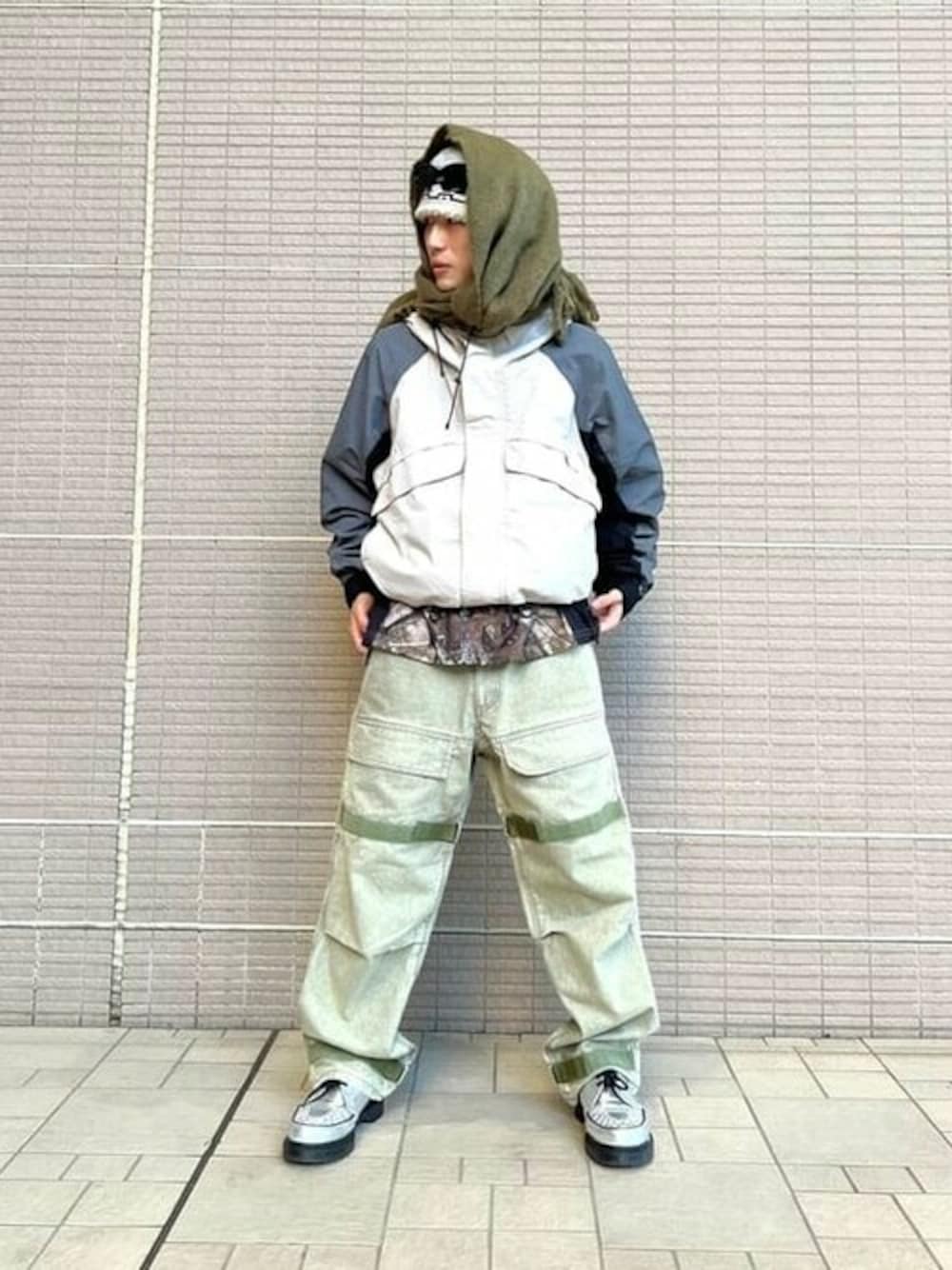 ベージュ系のナイロンジャケット、グリーン系のその他パンツ、グリーン系のマフラーを着用したメンズの冬コーディネートの1枚目の写真