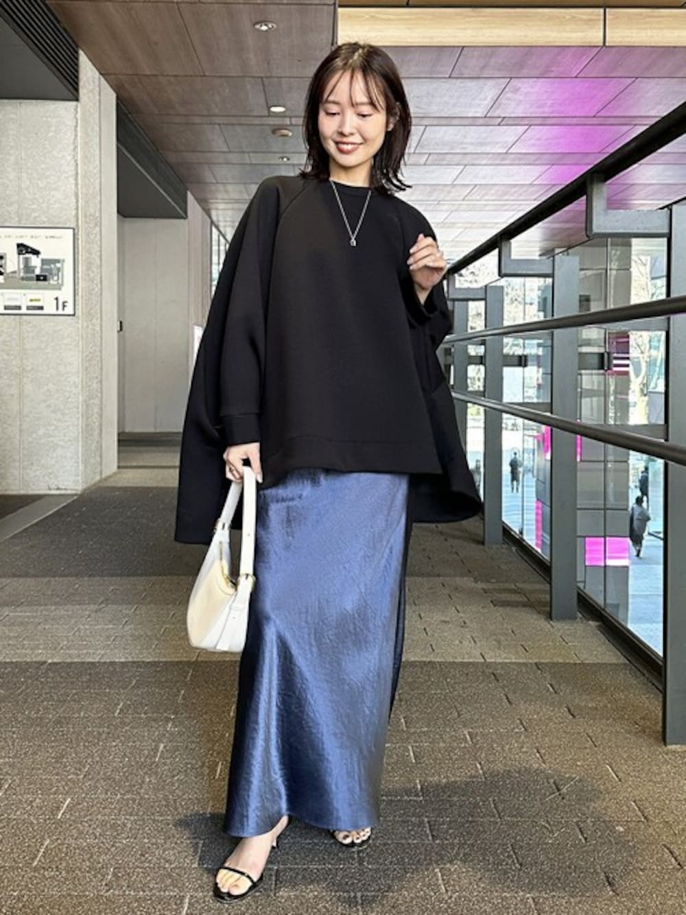 ブラック系のTシャツ/カットソー、ブルー系のスカートを着用したレディースの冬コーディネートの1枚目の写真
