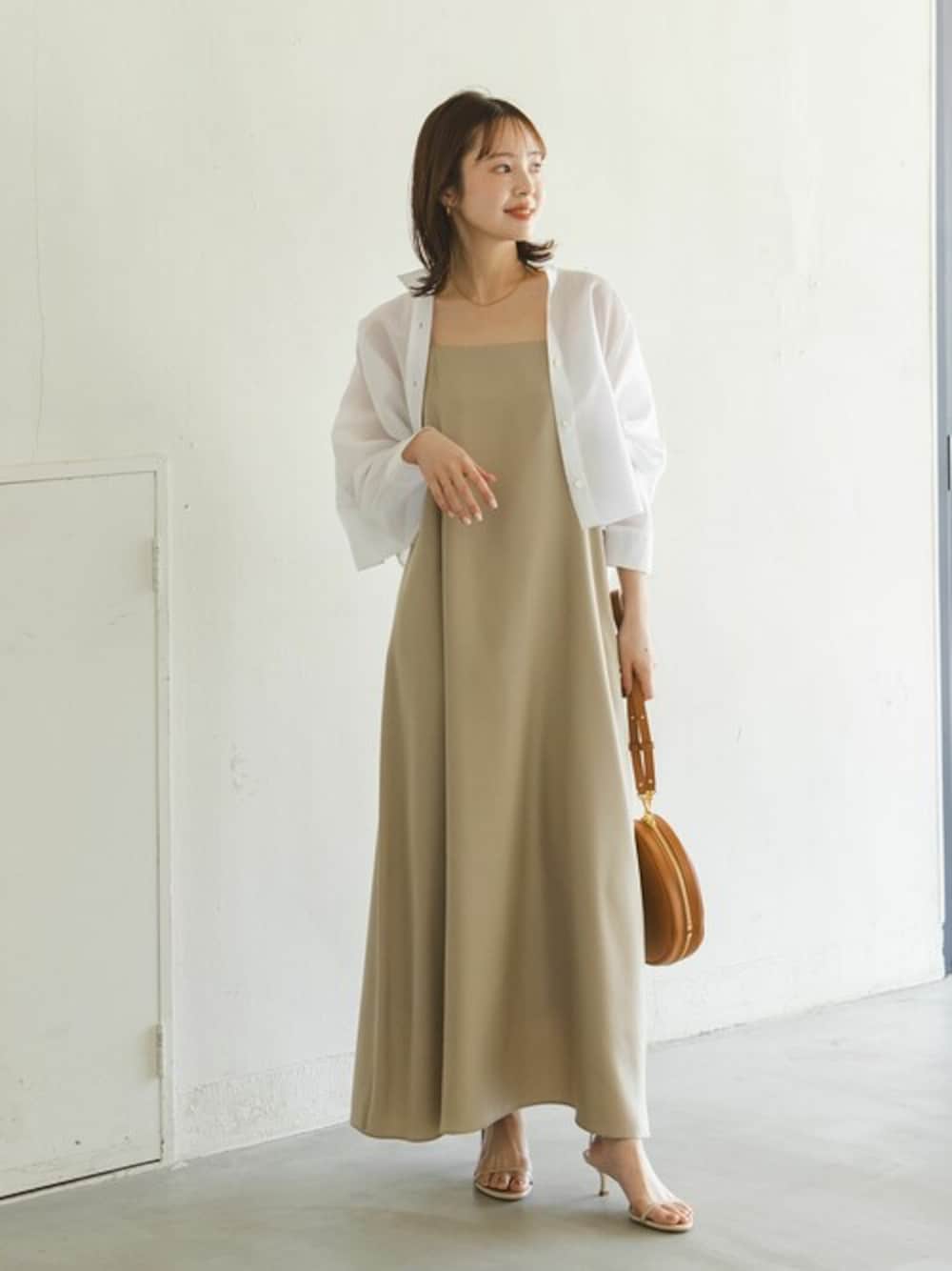 ホワイト系のシャツ/ブラウス、ベージュ系のワンピース、イエロー系のショルダーバッグを着用したレディースの春コーディネートの1枚目の写真