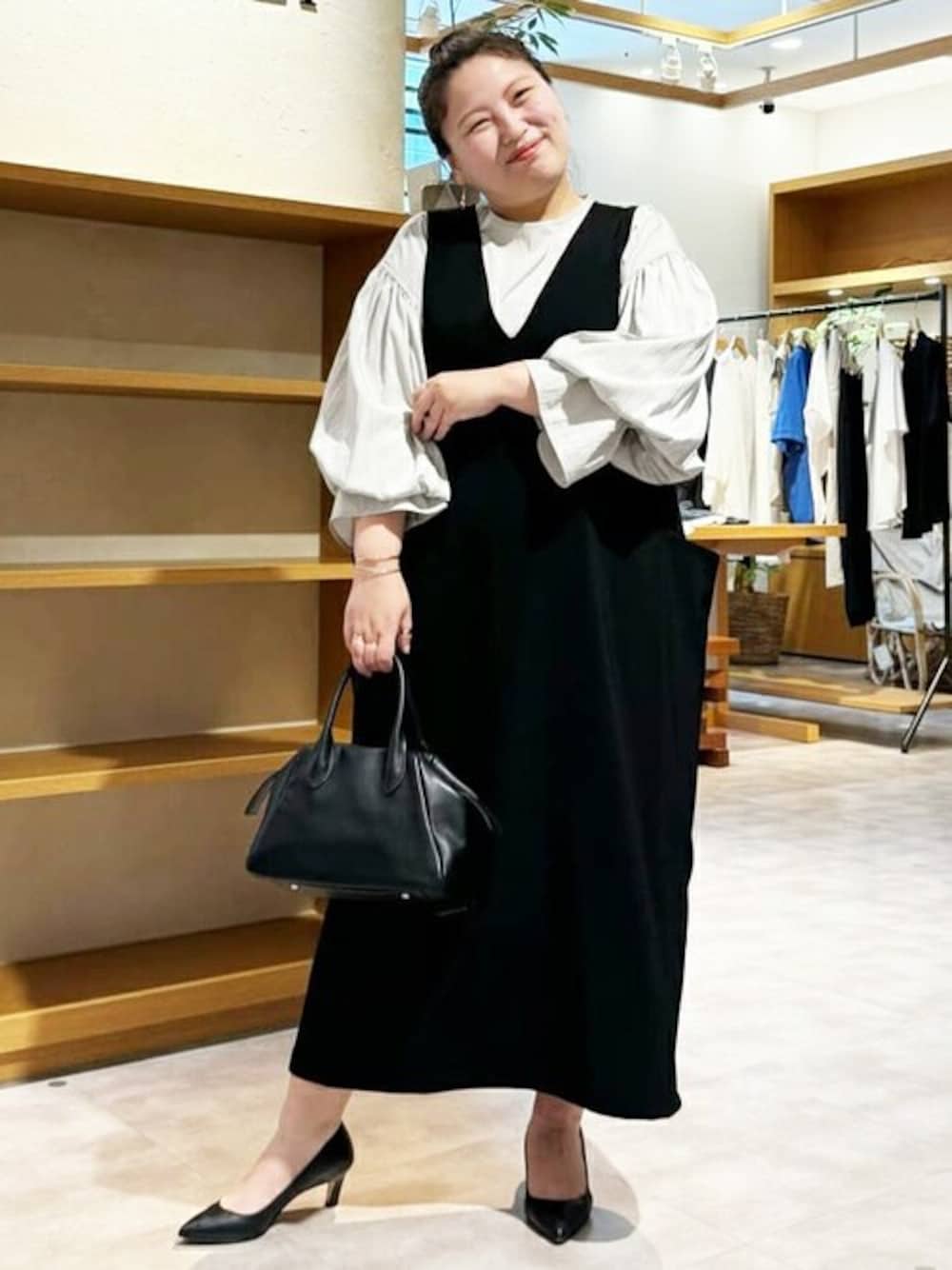 ブラック系のボストンバッグ、ブラック系のワンピース、グレー系のシャツ/ブラウスを着用したレディースの夏コーディネートの1枚目の写真