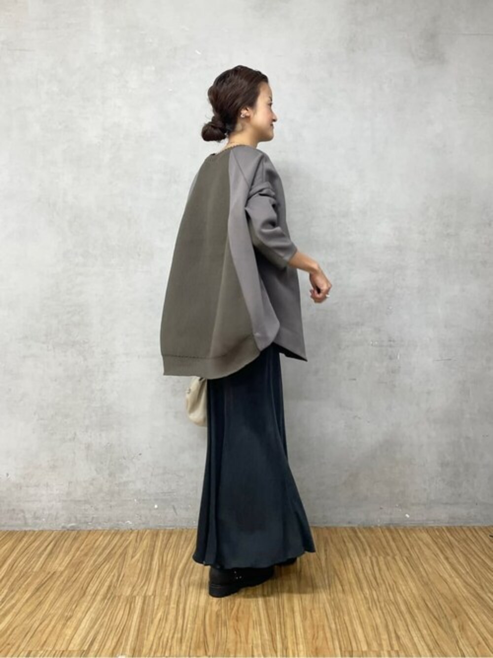 グレー系のショルダーバッグ、グリーン系のTシャツ/カットソー、ブラック系のスカートを着用したレディースの夏コーディネートの1枚目の写真