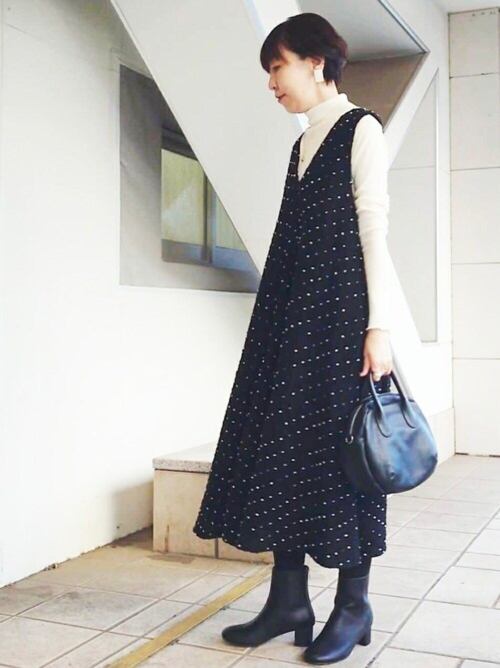 ブラック系のワンピース、ホワイト系のTシャツ/カットソー、ブラック系のショルダーバッグを着用したレディースの秋コーディネートの1枚目の写真