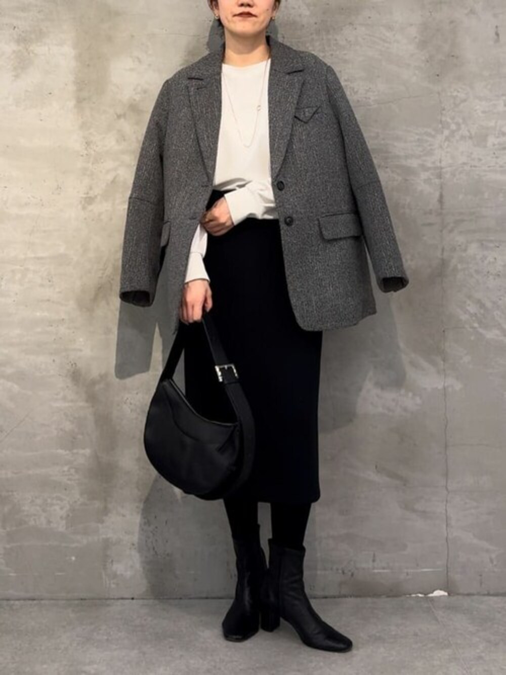 ホワイト系のTシャツ/カットソー、ブラック系のスカート、グレー系のその他アウターを着用したレディースの秋コーディネートの1枚目の写真