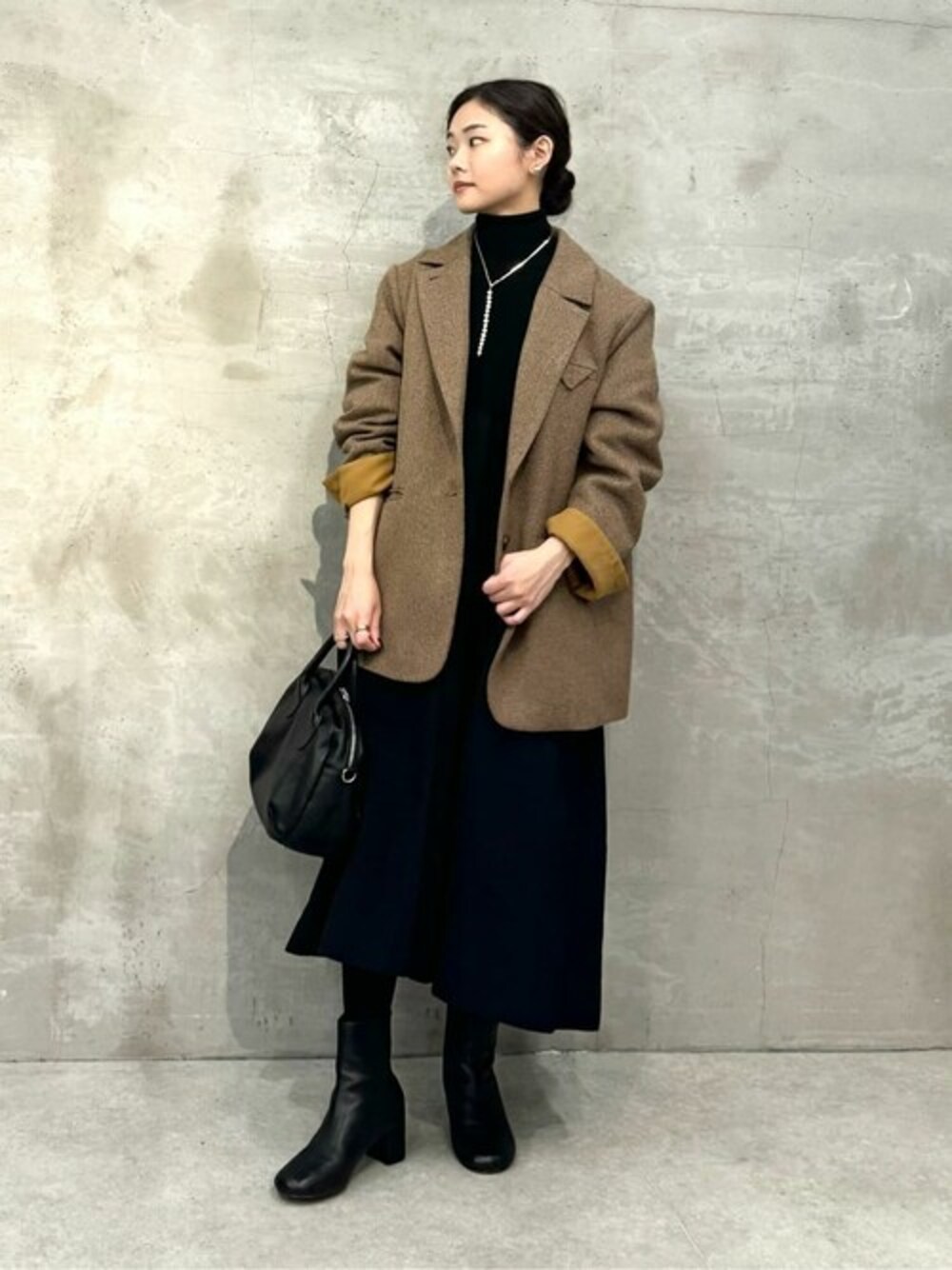 ブラウン系のその他アウター、ブラック系のワンピース、ブラック系のショルダーバッグを着用したレディースの秋コーディネートの1枚目の写真