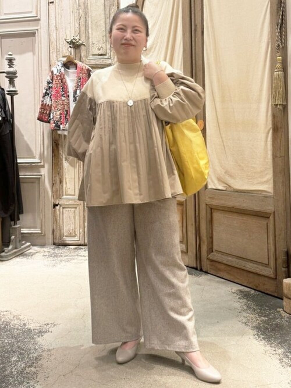ベージュ系のシャツ/ブラウス、ベージュ系のその他パンツ、イエロー系のショルダーバッグを着用したレディースの秋コーディネートの1枚目の写真
