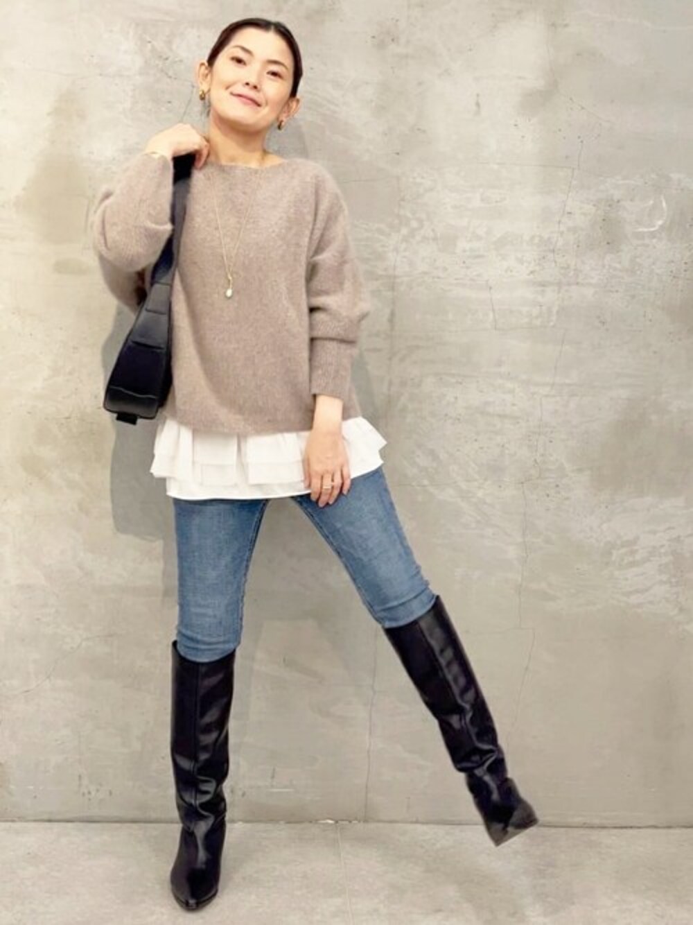 ホワイト系のキャミソール、ブラウン系のカーディガン/ボレロ、ブルー系のデニムパンツを着用したレディースの秋コーディネートの1枚目の写真