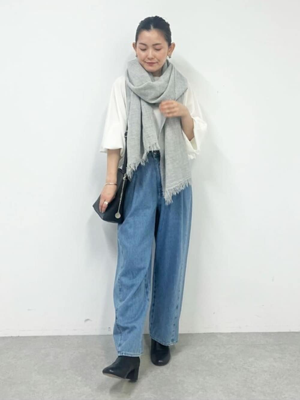 ブルー系のデニムパンツ、グレー系のマフラーを着用したレディースの秋コーディネートの1枚目の写真