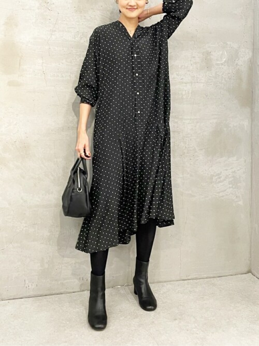 ブラック系のワンピース、ブラック系のブーツを着用したレディースの冬コーディネートの1枚目の写真