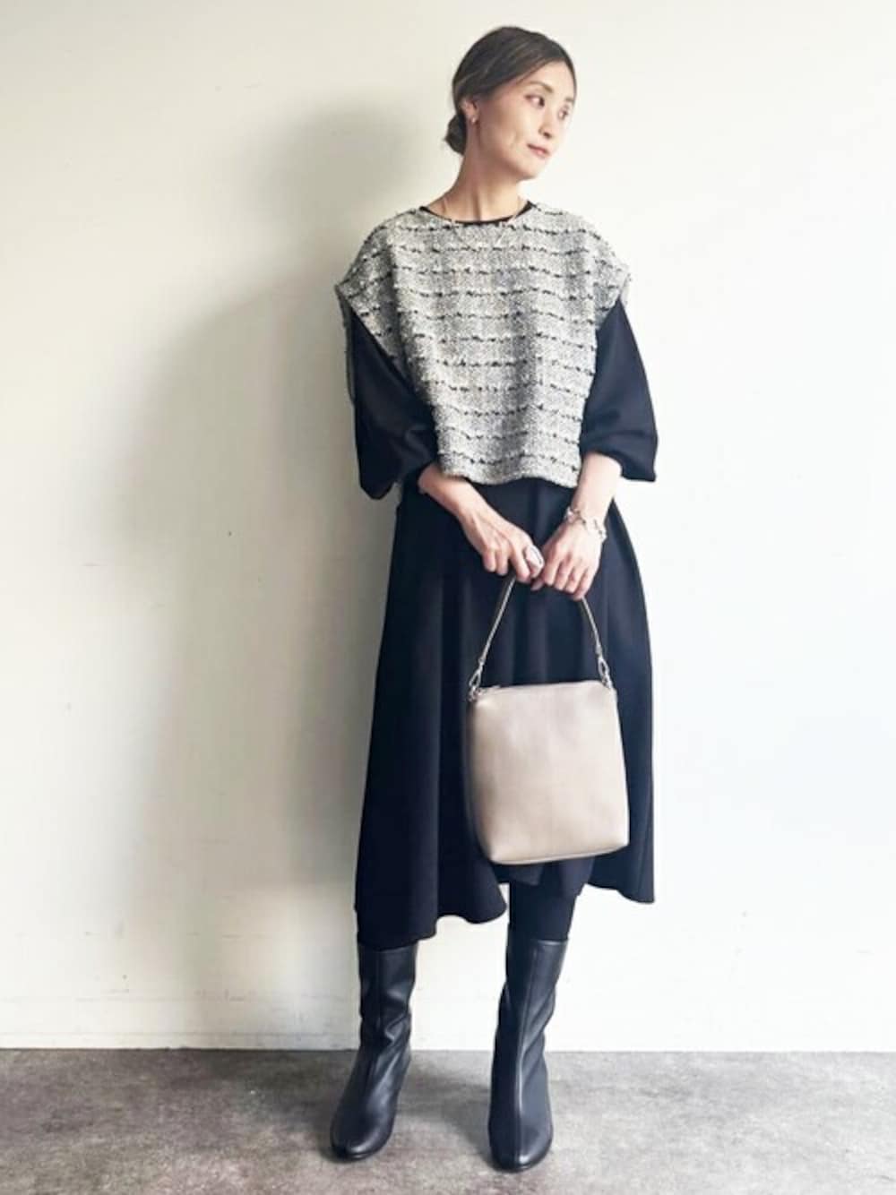 ブラック系のニット/セーター、ブラック系のワンピース、グレー系のショルダーバッグを着用したレディースの冬コーディネートの1枚目の写真